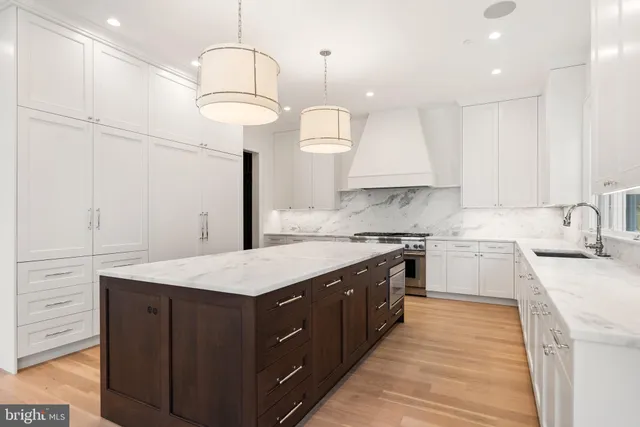 a kitchen with a sink dishwasher a stove and a dining table with wooden floor