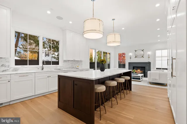 a kitchen with granite countertop a stove a sink a dining table and chairs