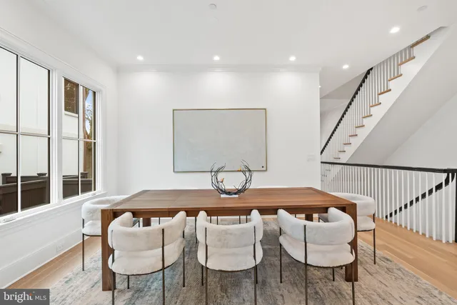 a table and chairs in a room with wooden floor