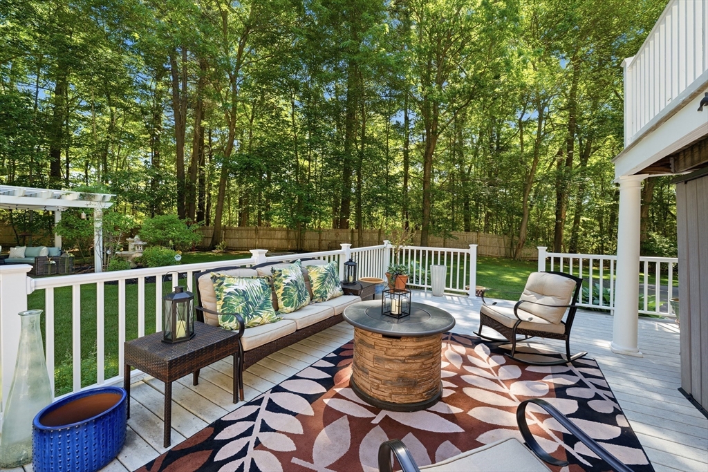 25 Haymeadow Road Boxford, MA 01921 - Photo 35 of 42 a balcony with wooden benches and a potted plant