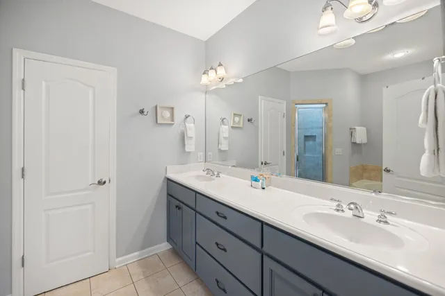 a bathroom with a double vanity sink a mirror and a shower