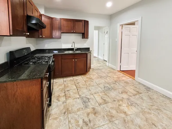 a kitchen with stainless steel appliances granite countertop a stove a sink and a refrigerator