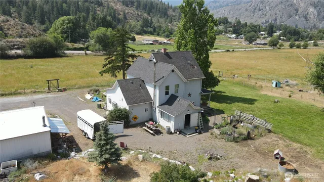 an aerial view of a house with garden space and mountain view in back
