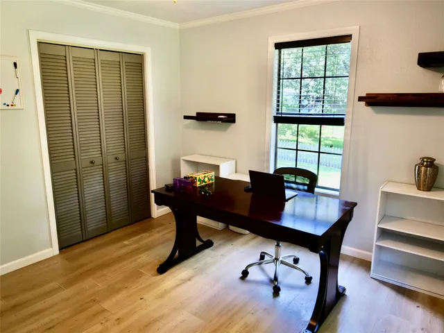 a view of a workspace with furniture and a window