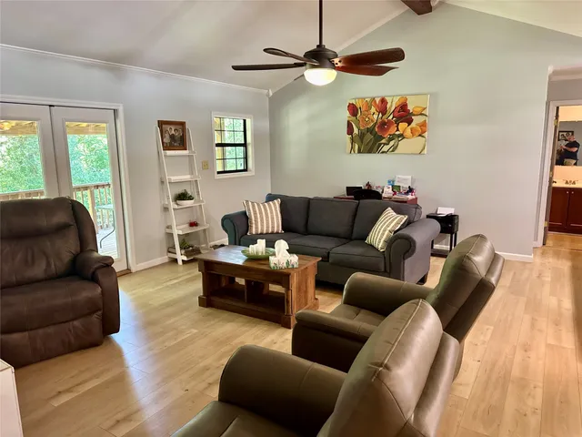 a living room with furniture ceiling fan and a window