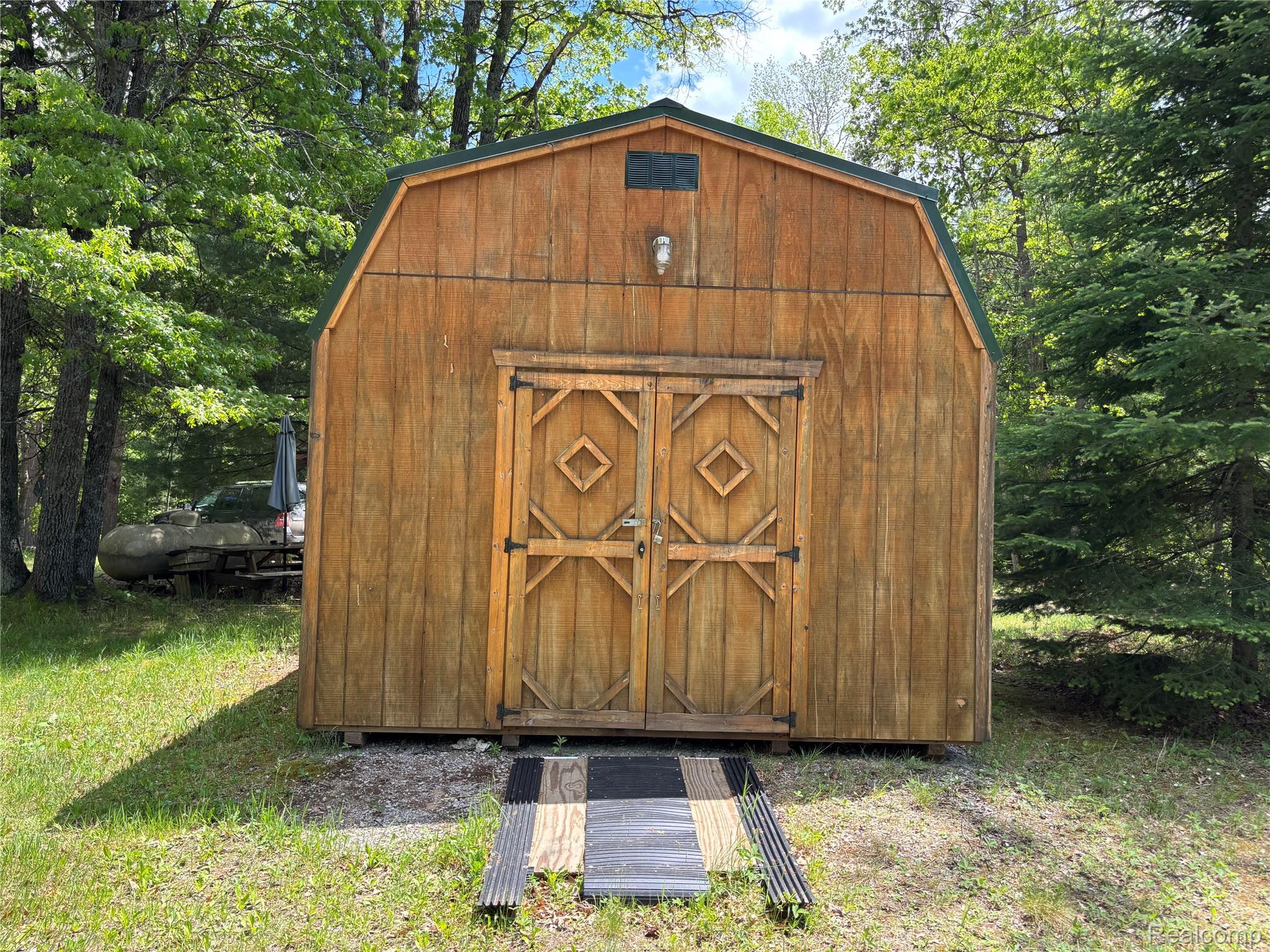 955 Aeronca Road Luzerne, MI 48636 - Photo 4 of 20 Wood-sided barn structure with a gambrel roof and green trim