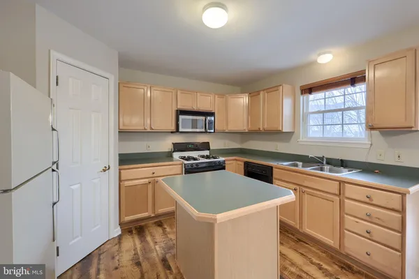 a kitchen with a sink a stove a refrigerator and cabinets