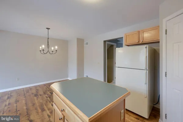 a view of a kitchen with refrigerator and wooden floor