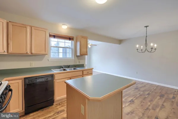 a kitchen that has a sink a stove cabinets counter space and a window