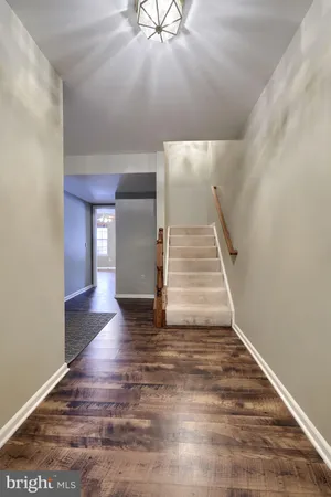 wooden floor with a chandelier