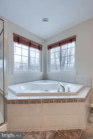 a bathroom with a granite countertop sink and bathtub