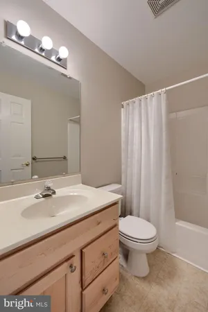 a bathroom with a sink a toilet a mirror and shower