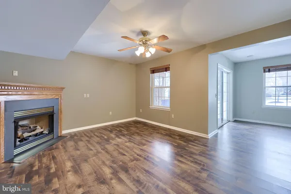 a view of an empty room with window and fireplace