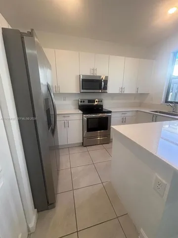 a metallic refrigerator freezer sitting in a kitchen