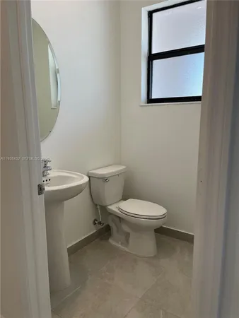 a white toilet sitting next to a bathroom sink