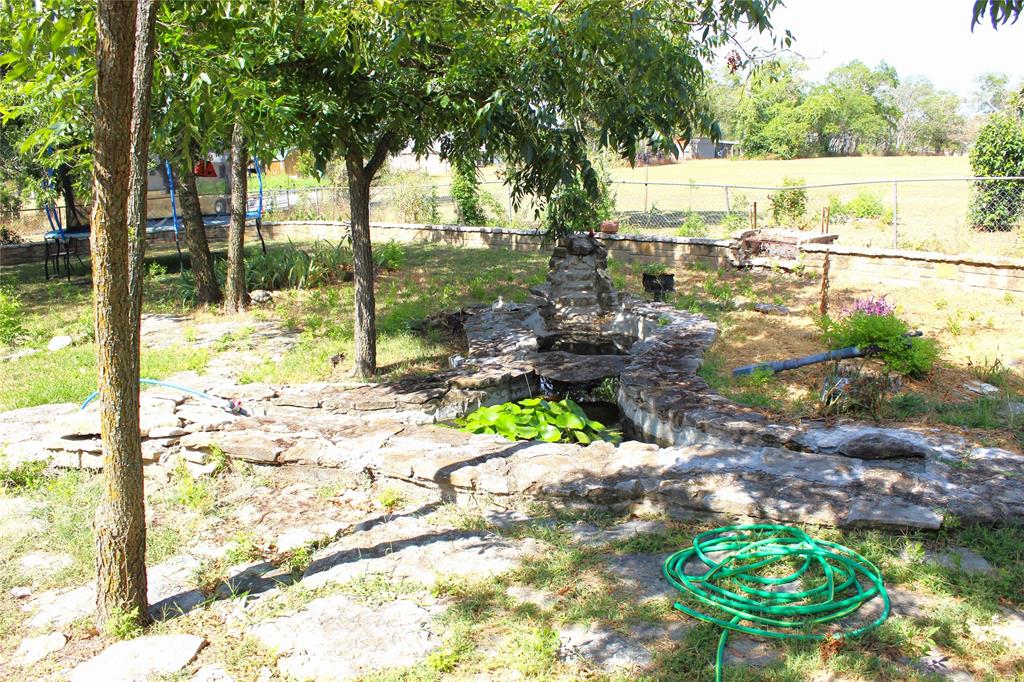 312 Magnolia Street Hico, TX 76457 - Photo 15 of 16 a view of a garden with a bench in the patio