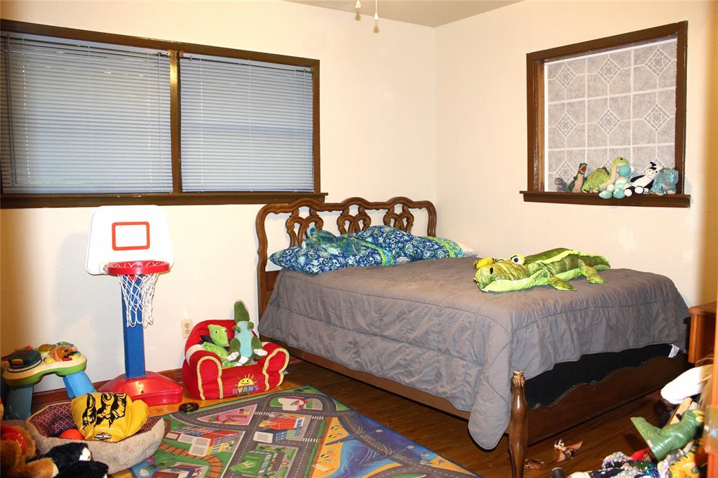 312 Magnolia Street Hico, TX 76457 - Photo 10 of 16 a bedroom with a bed table and a window