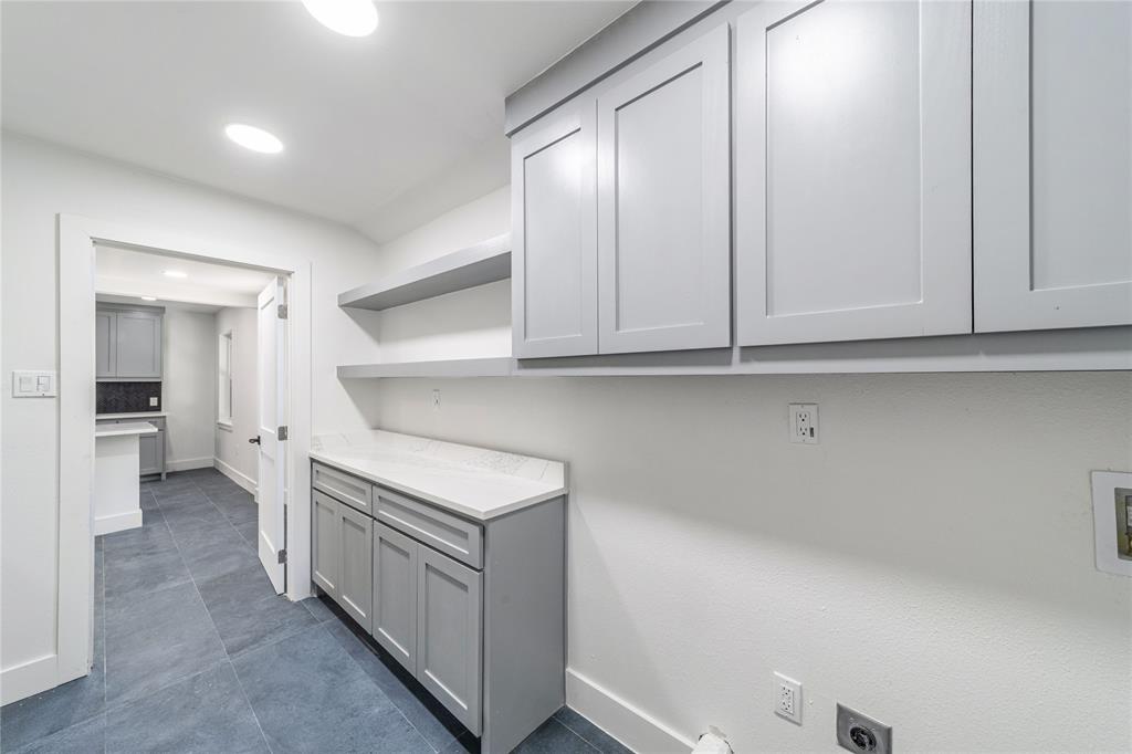 932 Treasure Road Garland, TX 75041 - Photo 12 of 23 a kitchen with white cabinets and white appliances
