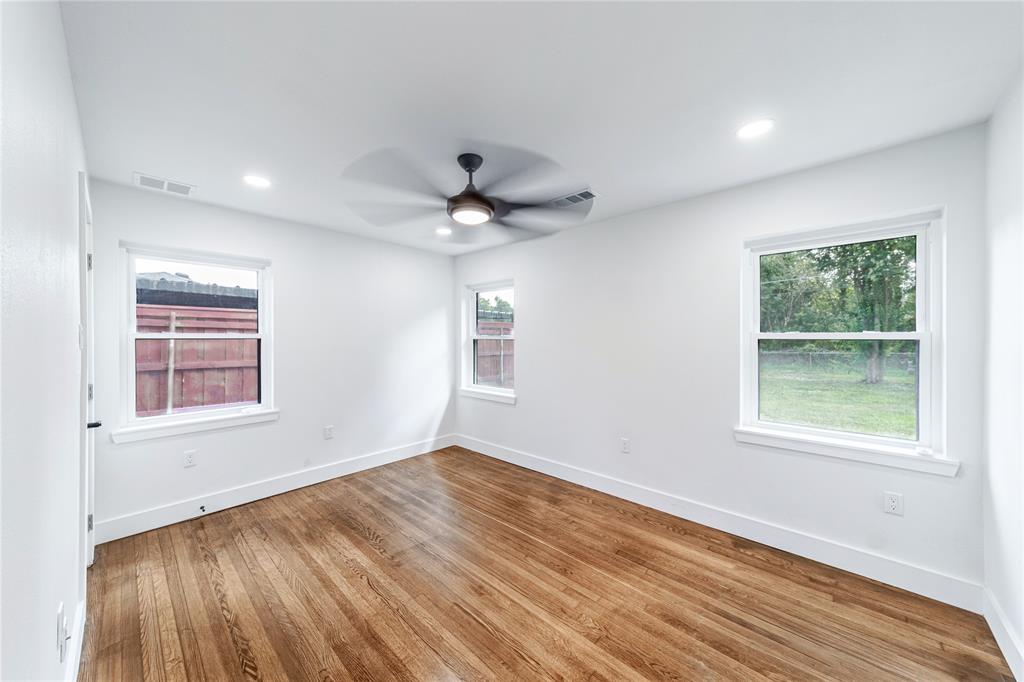 932 Treasure Road Garland, TX 75041 - Photo 15 of 23 an empty room with wooden floor and windows