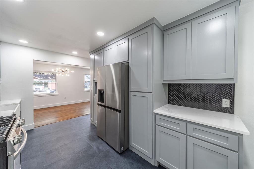 932 Treasure Road Garland, TX 75041 - Photo 7 of 23 a kitchen with a refrigerator and a sink