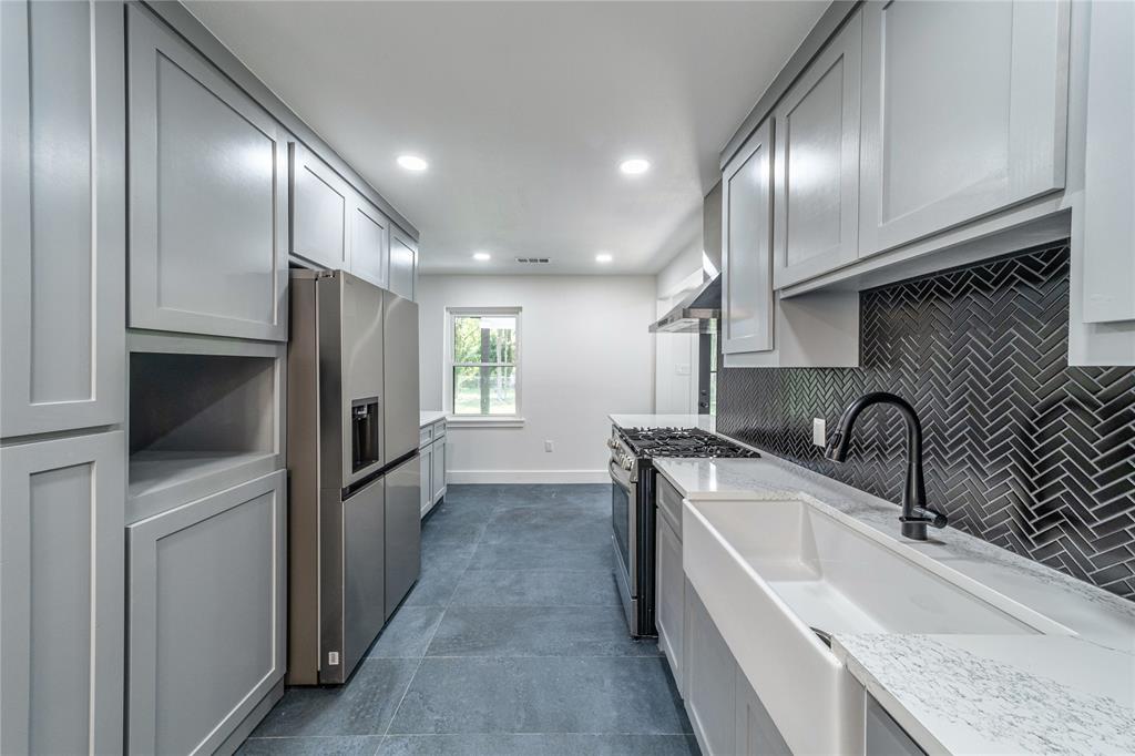 932 Treasure Road Garland, TX 75041 - Photo 8 of 23 a kitchen with granite countertop a sink stainless steel appliances and cabinets