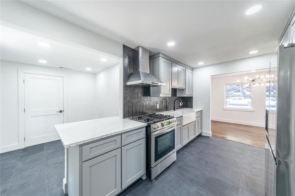 932 Treasure Road Garland, TX 75041 - Photo 9 of 23 a large kitchen with stainless steel appliances granite countertop a stove and a sink