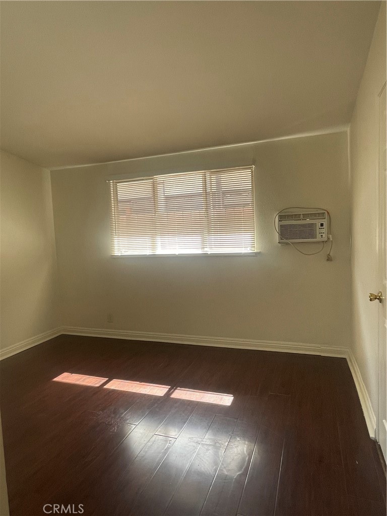 528 Cherry, Unit B Long Beach, CA 90802 - Photo 11 of 16 an empty room with wooden floor and windows