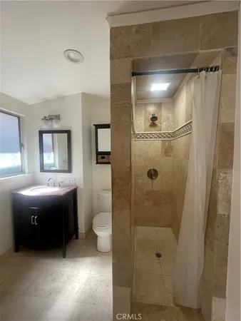 a bathroom with a granite countertop sink mirror and shower