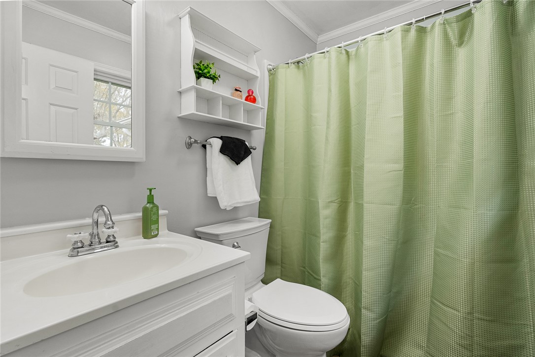 1403 Hanover Road Anderson, SC 29621 - Photo 18 of 40 This bathroom features a simple vanity, toilet, and a practical shower area with a refreshing curtain.