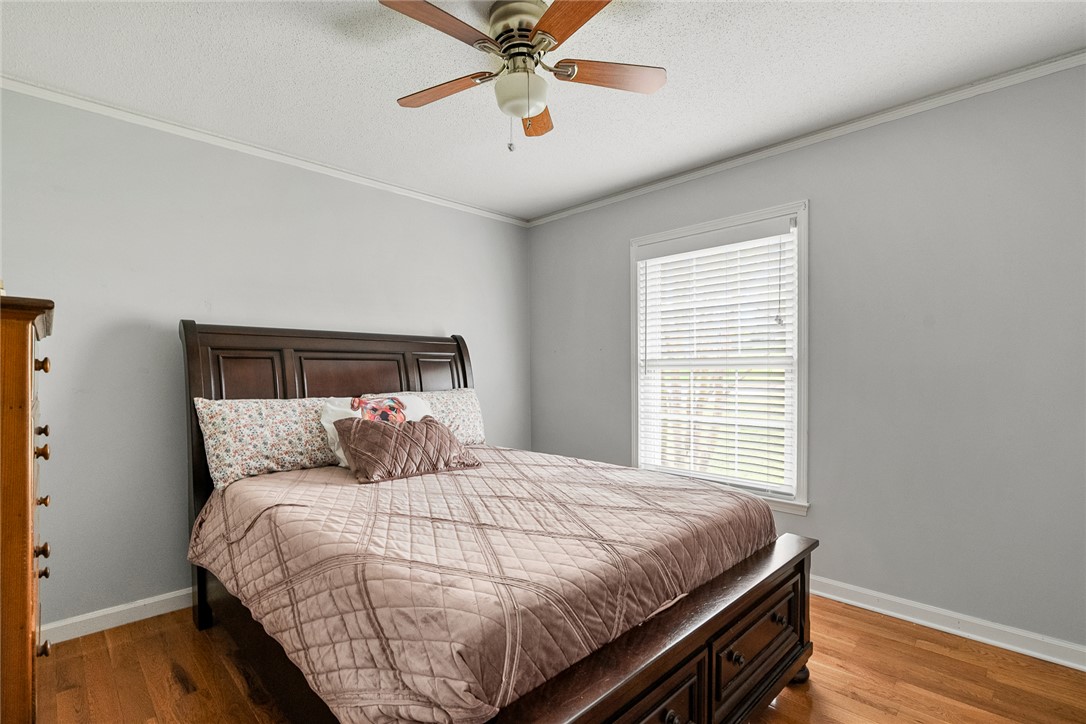 1403 Hanover Road Anderson, SC 29621 - Photo 19 of 40 This spacious bedroom offers ample natural light and comfortable wood flooring, creating a relaxing atmosphere.