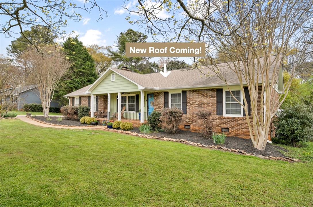 1403 Hanover Road Anderson, SC 29621 - Photo 2 of 40 This charming residence features a classic brick exterior and a welcoming porch, nestled amidst lush landscaping.