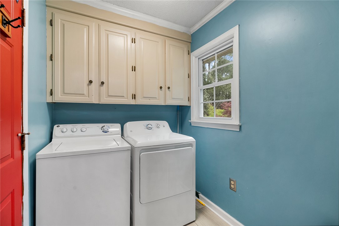 1403 Hanover Road Anderson, SC 29621 - Photo 22 of 40 This laundry room features ample cabinetry and natural light, combining utility with a bright aesthetic.