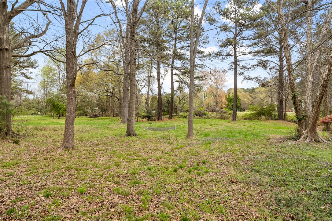 1403 Hanover Road Anderson, SC 29621 - Photo 33 of 40 A tranquil yard with lush green grass, towering trees, and ample space for outdoor relaxation.