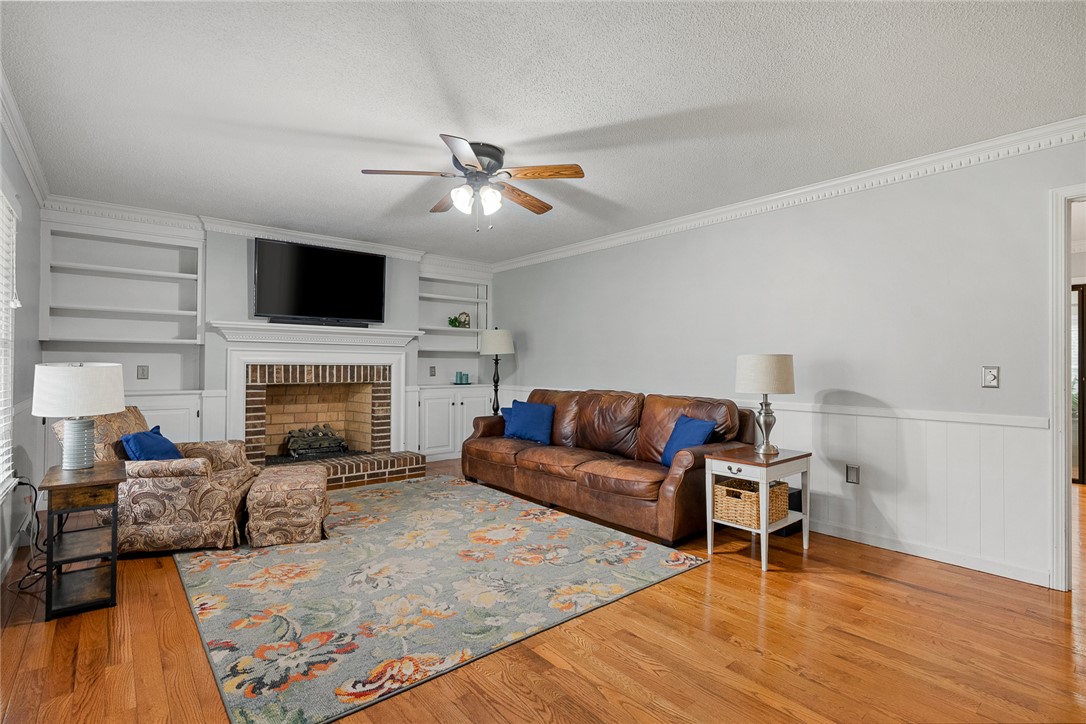 1403 Hanover Road Anderson, SC 29621 - Photo 7 of 40 This inviting living room features a fireplace, built-in shelving, and hardwood flooring.