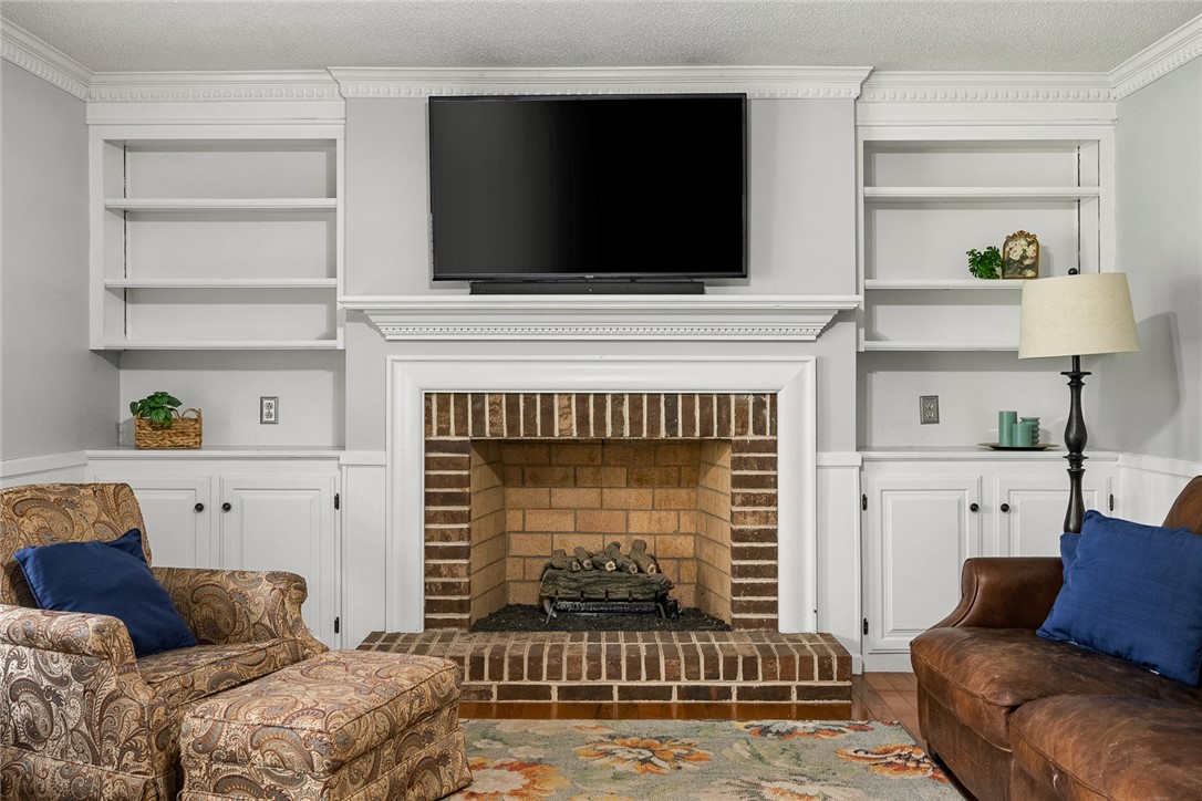 1403 Hanover Road Anderson, SC 29621 - Photo 9 of 40 This inviting living space features a cozy brick fireplace framed by custom built-in shelving.