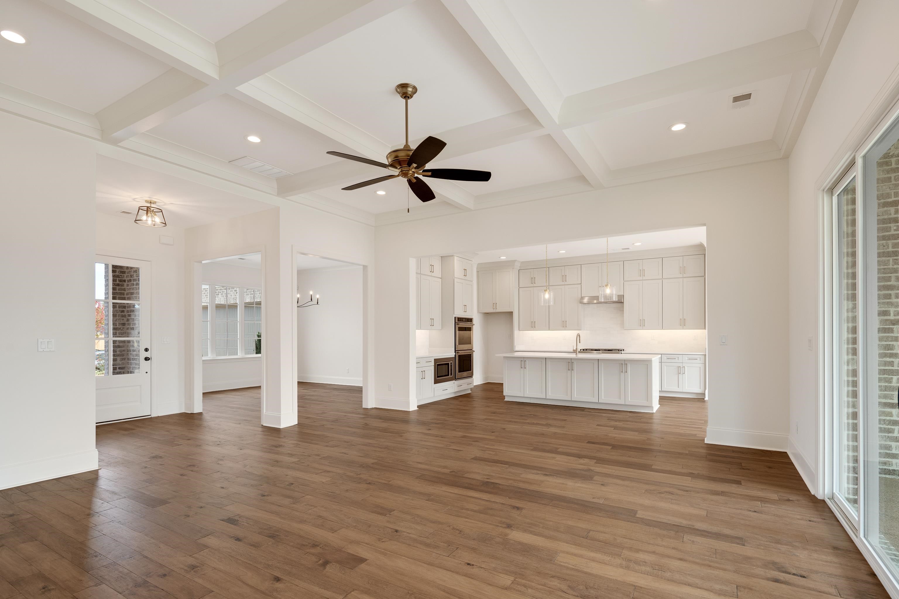 10145 Nighthawk Cove Collierville, TN 38017 - Photo 4 of 25 a view of an empty room and kitchen with wooden floor