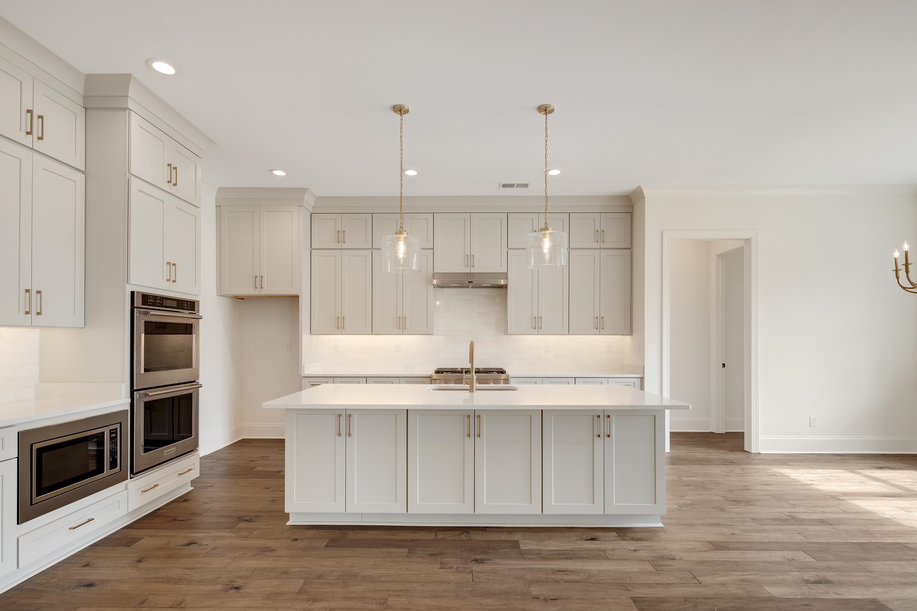 10145 Nighthawk Cove Collierville, TN 38017 - Photo 5 of 25 a kitchen with kitchen island granite countertop a sink cabinets and stainless steel appliances