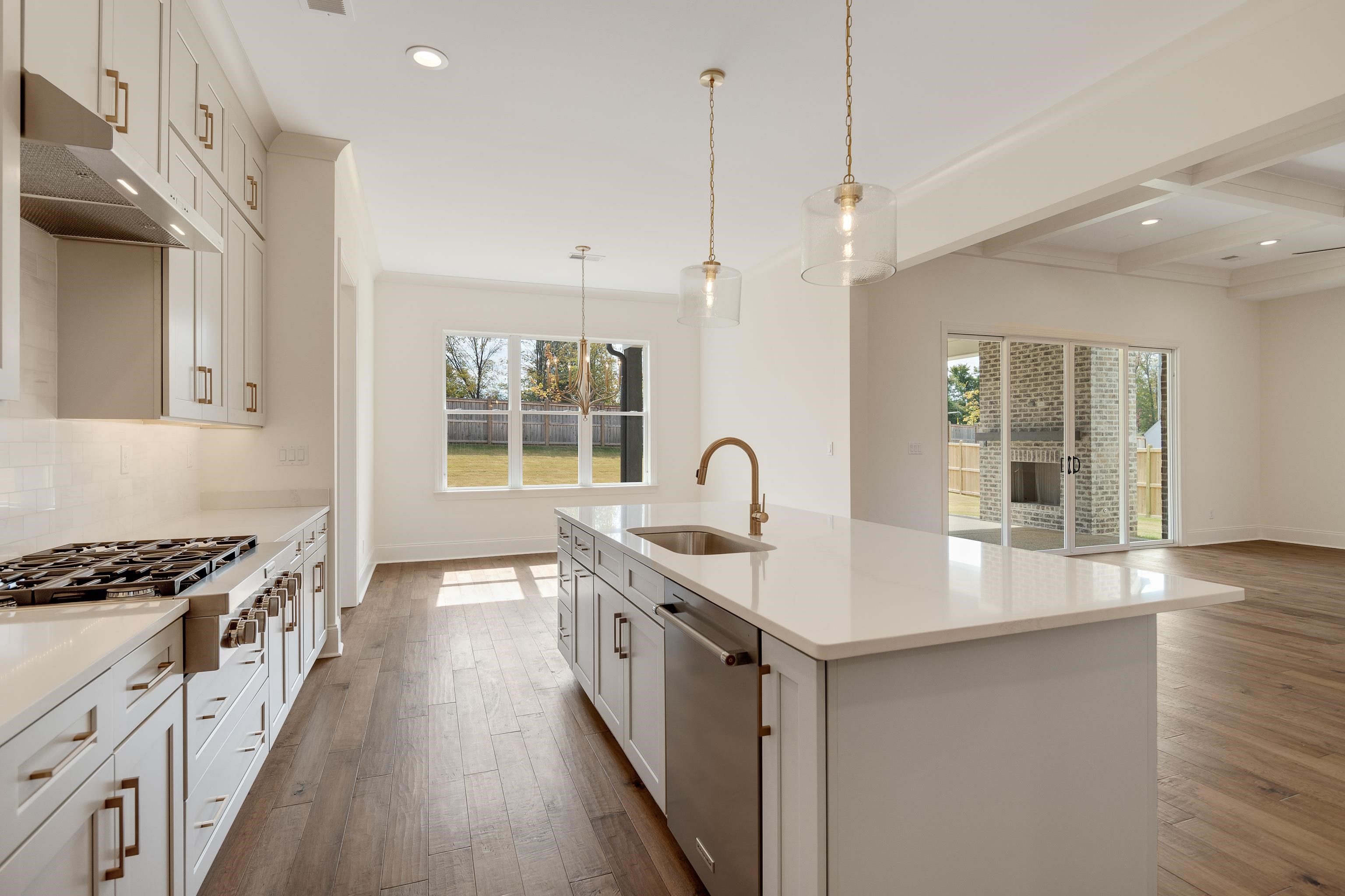 10145 Nighthawk Cove Collierville, TN 38017 - Photo 8 of 25 a kitchen with stainless steel appliances granite countertop a sink stove and wooden floor