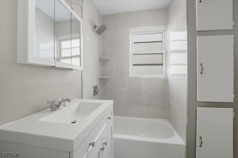 102 Exton Avenue, Unit 1 North Arlington, NJ 07031 - Photo 16 of 18 a white bath tub sitting next to a white sink