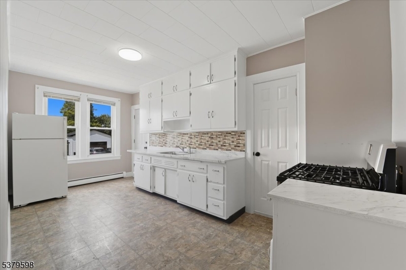 102 Exton Avenue, Unit 1 North Arlington, NJ 07031 - Photo 17 of 18 a kitchen with white cabinets and white appliances