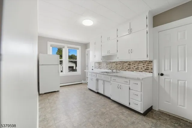a kitchen with granite countertop white cabinets and white appliances