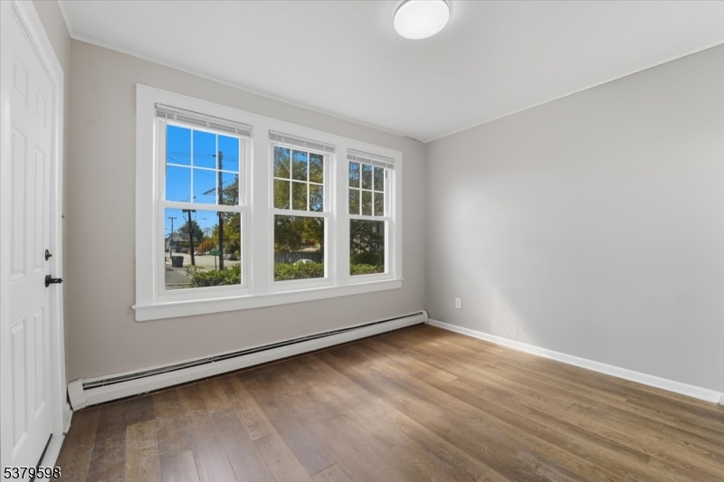 102 Exton Avenue, Unit 1 North Arlington, NJ 07031 - Photo 2 of 18 an empty room with wooden floor and windows