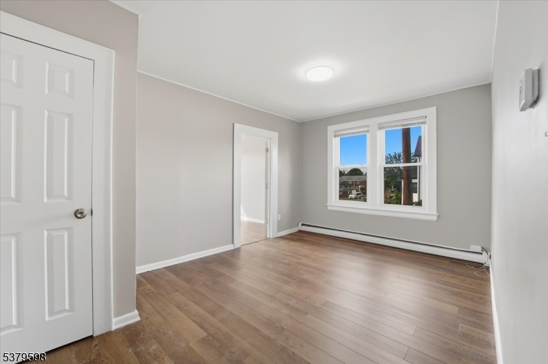102 Exton Avenue, Unit 1 North Arlington, NJ 07031 - Photo 6 of 18 a view of an empty room with window and wooden floor