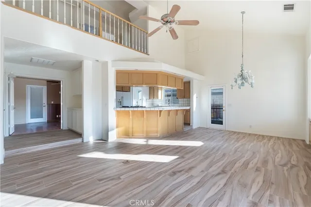 a view of a kitchen with wooden floor and a ceiling fan