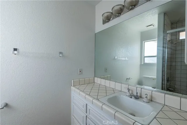 a bathroom with a granite countertop sink and a mirror