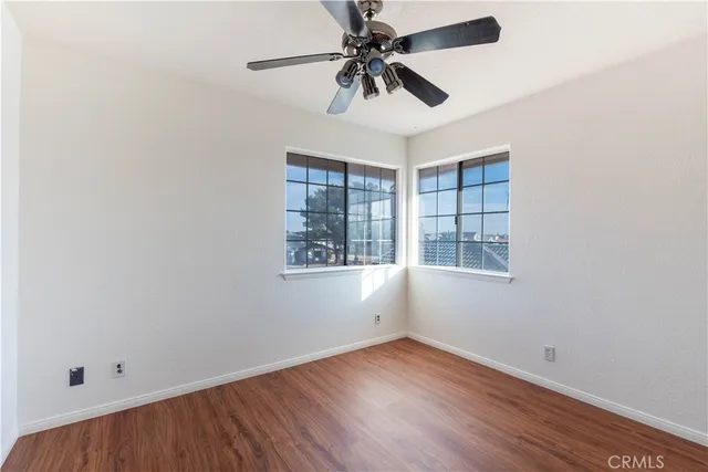 an empty room with a window and a fan