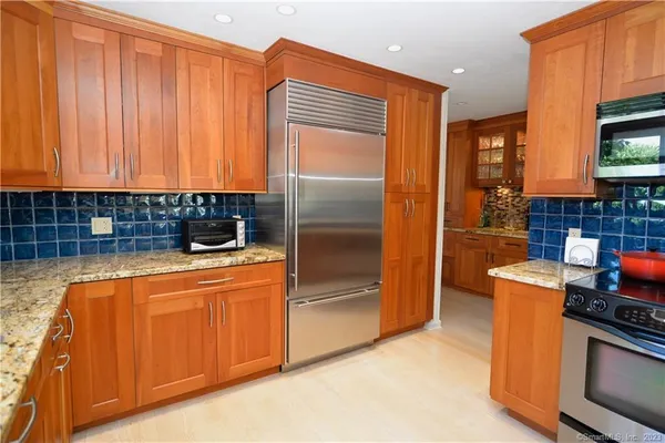 a kitchen with stainless steel appliances granite countertop a refrigerator a stove a sink and dishwasher