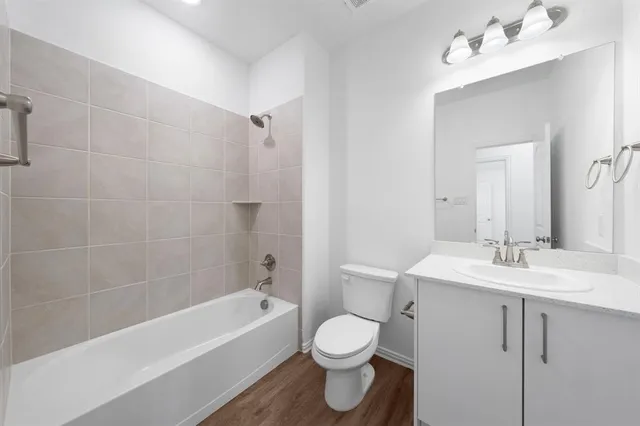 a bathroom with a bathtub shower sink mirror and toilet