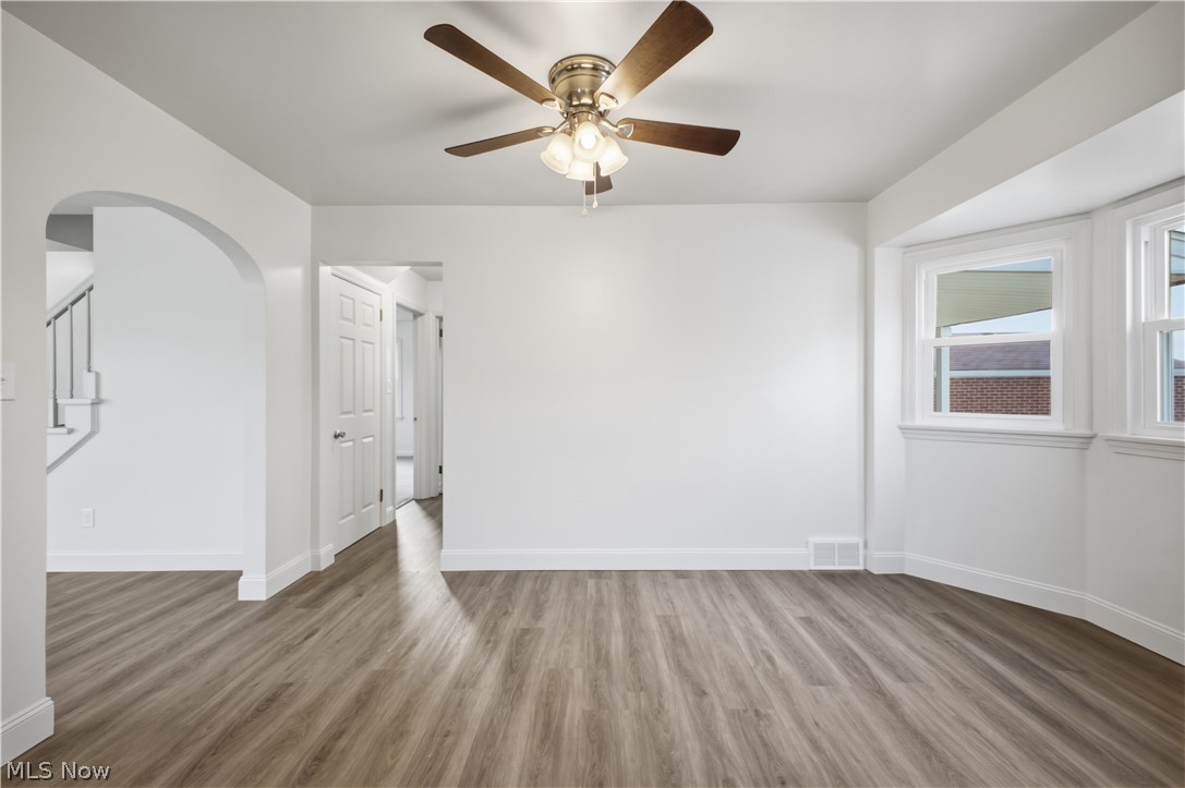 227 Wilson Street Struthers, OH 44471 - Photo 12 of 44 Spare room featuring arched walkways, a ceiling fan, and light wood-type flooring