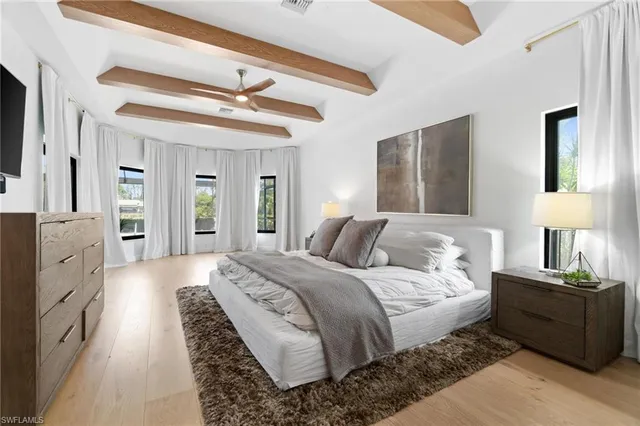 a spacious bedroom with a bed and a chandelier